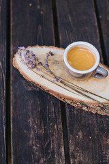 A cup of coffee on a wooden stand.