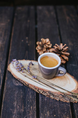 A cup of coffee on a wooden stand.