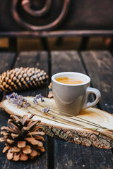 A cup of coffee on a wooden stand.