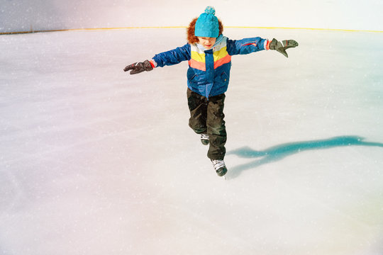 little boy skating on ice in winter nature