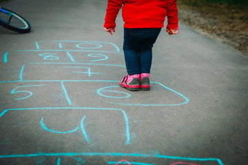 little girl play hopscotch on playground outdoors