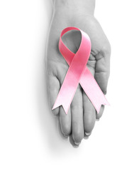 Female hand with pink ribbon on white background. Breast cancer awareness concept
