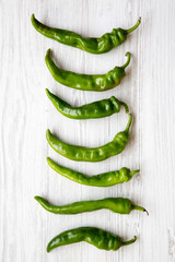 Green pepperoni peppers on white wooden table, top view. Flat lay, from above, overhead.