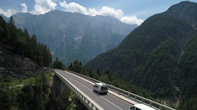 Aerial - Camper with bikes driving across the mountain viaduct in spring