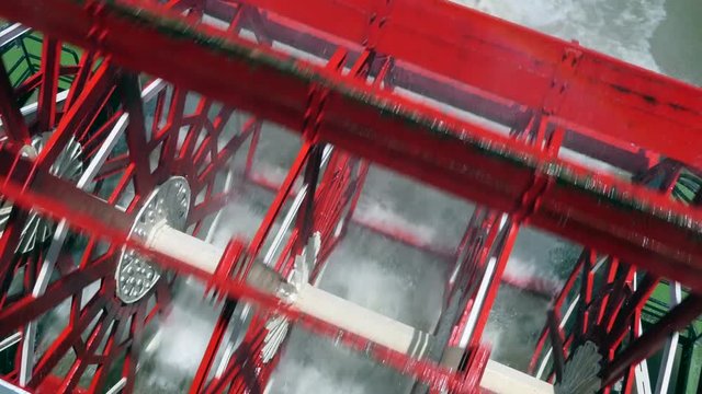 Paddle wheel of tourist steamboat on Mississippi river near New Orleans, Louisiana, United States of America leaving trail, ripples and waves on water