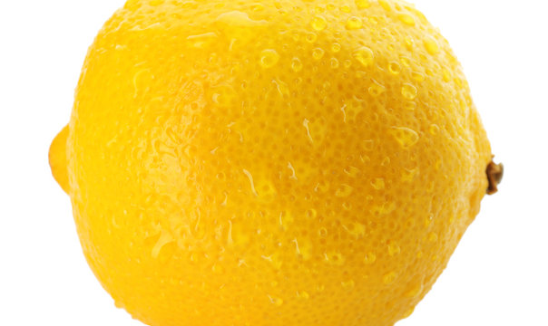 Ripe whole lemon with drops on white background, closeup