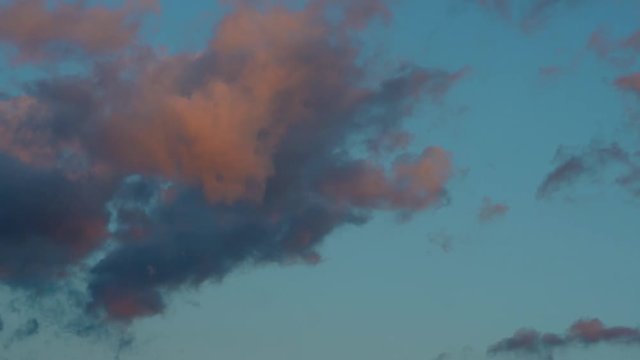 Nuvole schiarite dalla luce del tramonto corrono nel cielo