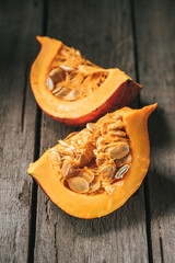 Close up view of raw pumpkin halves on wooden background
