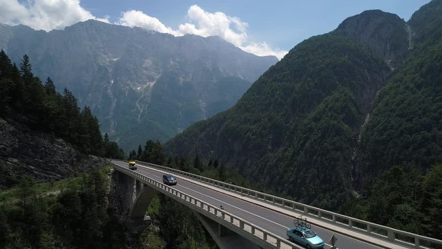 Aerial - Car and vans driving over the mountain viaduct in Alps