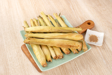 Delicious homemade izakaya-like roast baby corn in wooden background, Taiwan delicacies, top view, copy space