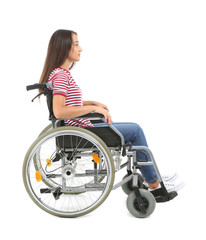 Young woman sitting in wheelchair on white background