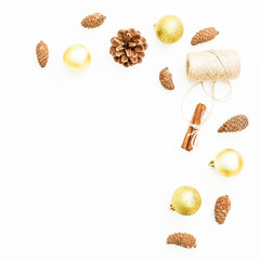 New Year frame of golden tree decoration, twine and pine cones on white background. Flat lay, top view