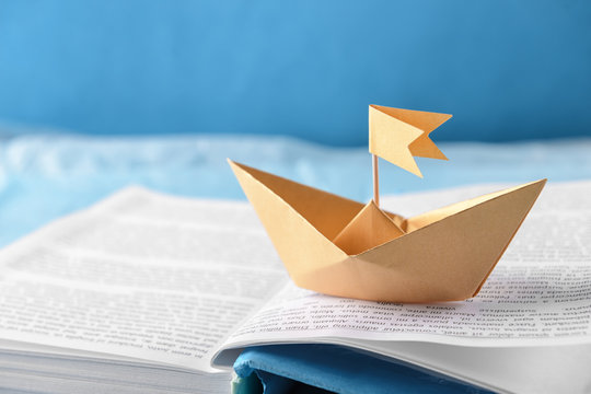 Origami boat on open book, closeup