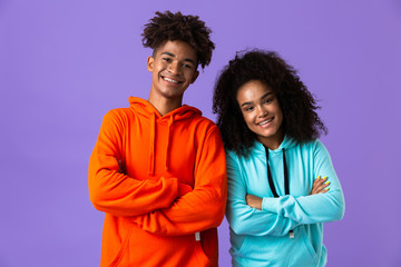 Young cute african couple posing isolated over violet background.