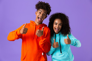 Happy young cute african couple posing isolated showing thumbs up gesture.