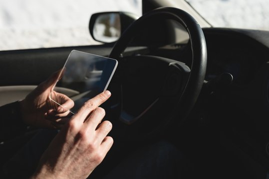 Man using glass digital tablet in car