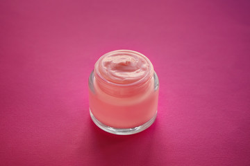 Jar with body cream on color table
