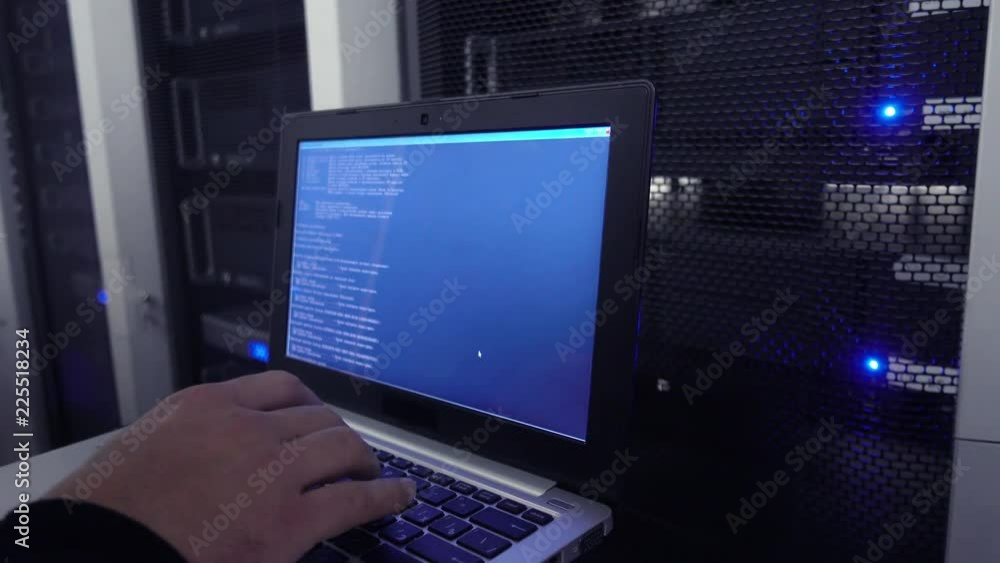 Poster data center engineer holds laptop and tests the stability of the system. the image has a slight nois