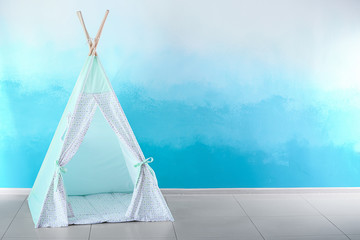 Cozy play tent for kids near color wall © Pixel-Shot