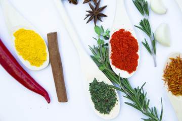 Dry spices and herbs in glass jar with a cork, a bowl of cherry tomatoes and chili peppers, white background