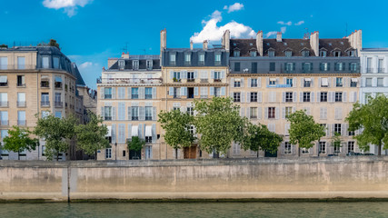 Fototapeta na wymiar Paris, view of ile saint-louis and quai d'Orleans, typical facades and quays in summer 