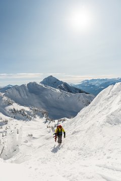Skier walking with ski board on a snowy mountain