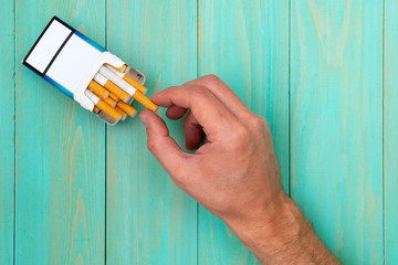 Hand takes out cigarette from pack