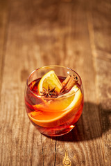 close up view of hot mulled wine drink with orange pieces and anise stars on wooden tabletop