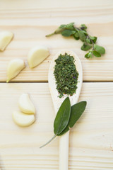 Cooking Hot Spicy Food Concept. Dry spices, beans and herbs in wooden spoon and plastic cup on light wooden table