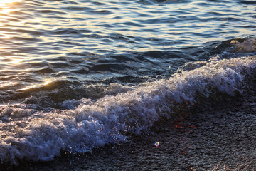 Waves at sea in the rays of sunset