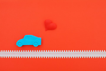 blue kinetic sand car and red heart on pink background