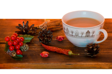 Coffee, spices and pine cones on a wooden background. Christmas concept. A cup of hot coffee with milk, cinnamon and chili on a wooden table.