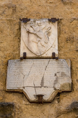 Lion plaque with latin inscription underneath in the beautiful hilltop town of San Gimignano, Italy