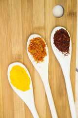 Cooking Hot Spicy Food Concept. Dry spices and herbs in wooden spoon on a cutting board