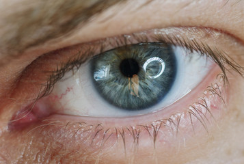 Blue man eye with contact lens, macro shot. Shallow depth of field.