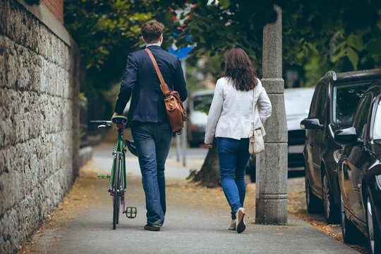 Business Colleagues Walking On Sidewalk In City