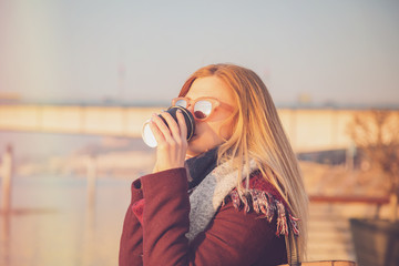 Beautiful woman drinking coffee outdoors.