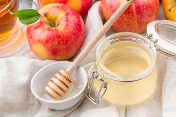 Jewish holiday Rosh Hashanah background with honey and apples on wooden table.