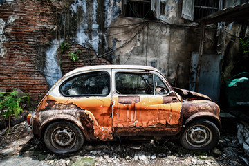 Obraz na płótnie Canvas Rusty old car abandoned beside old house
