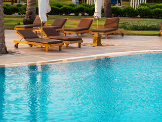 Beach lounger, sun lounger near the pool with turquoise water