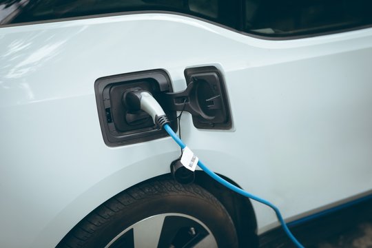 Fototapeta Electric car charging at charging station