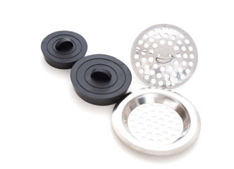 Sink strainers and black rubber domestuic plugs on white background.