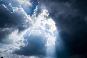 Sun behide clouds and blue sky, silhouette