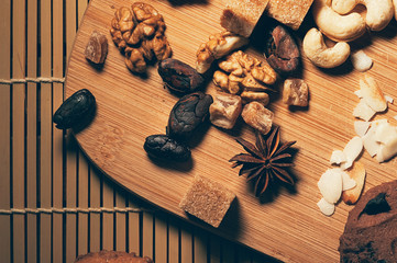Nuts, dried fruit, cocoa beans, star anise and other ingredients on a cutting board