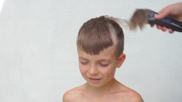 Child of seven years shear hair. Self-isolation, quarantine of viral infection COVID 19. Healthy lifestyle.