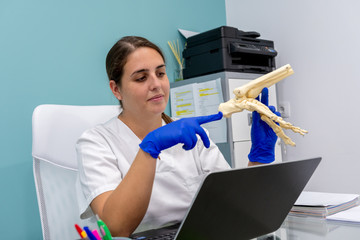Female chiropodist, attending a clinic patient and performing podiatric treatments