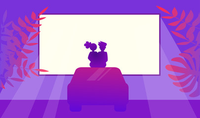 Couple in love watching movie sitting on car. Outdoor cinema Night