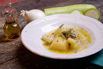Zucchini dish in broth with potato and onion and herbs  