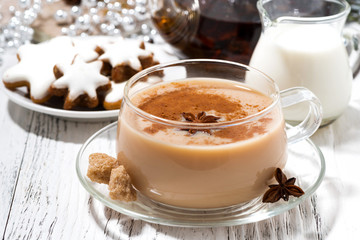 cup of masala tea and Christmas cookies on white background