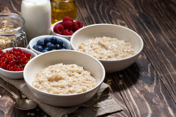 homemade oatmeal and berries on wooden background, closeup